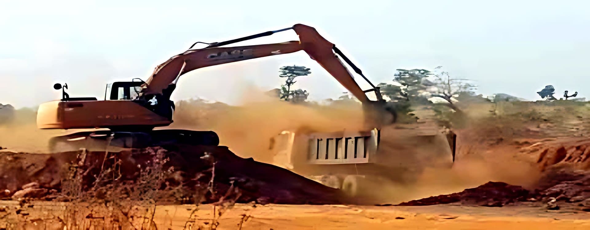 Excavator loading a tipper truck on a road site